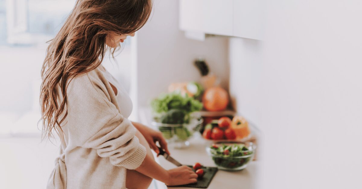 Woman chopping fresh vegetables in a bright kitchen